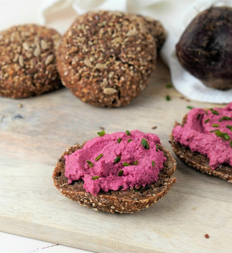 Proteinbrötchen mit Rote Beete Streich auf einem Holzbrett
